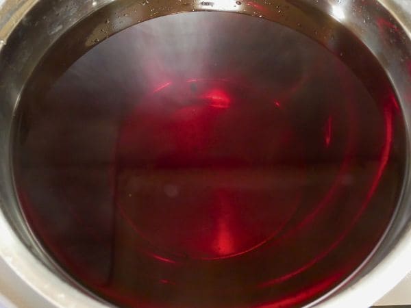 液体だけをボウルに濾した赤紫蘇ジュースの画像。