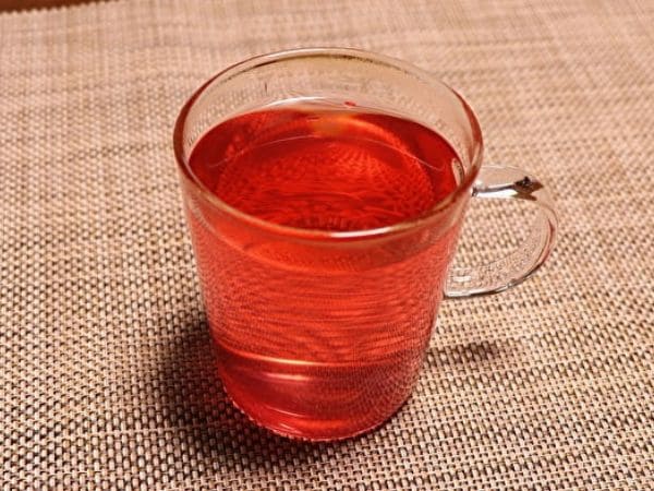 耐熱ガラスのコップに赤紫蘇ジュースとお湯を入れた画像。
