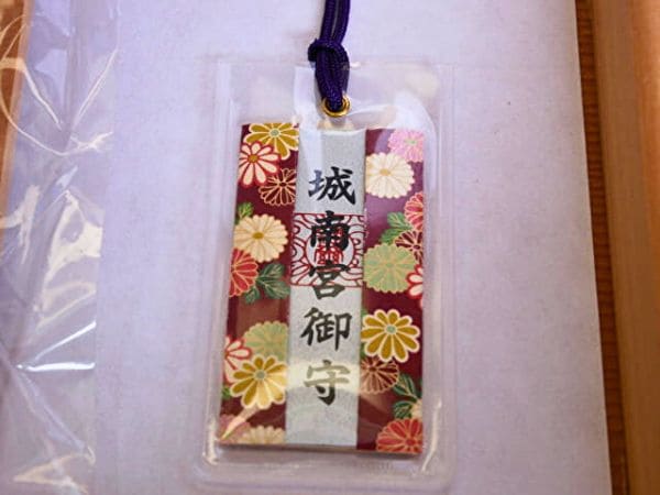 京都・城南宮の菊の花守り。臙脂の地に色とりどりの菊が散りばめられた布で装飾されている。