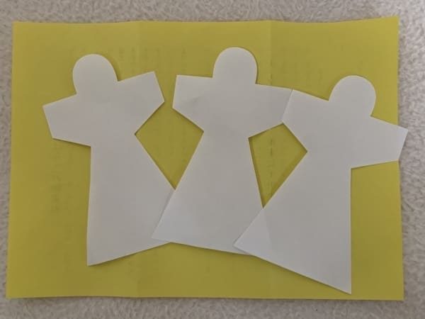 夏越の祓で用いられる紙の人形が3枚置かれた画像。